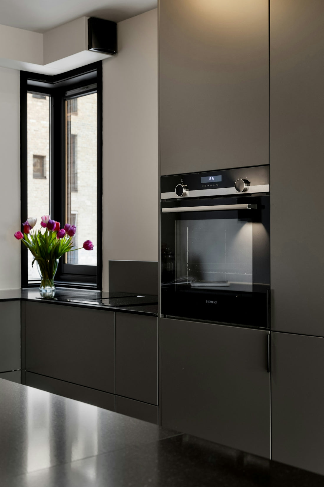 A modern kitchen with stainless steel cabinets and black counter tops