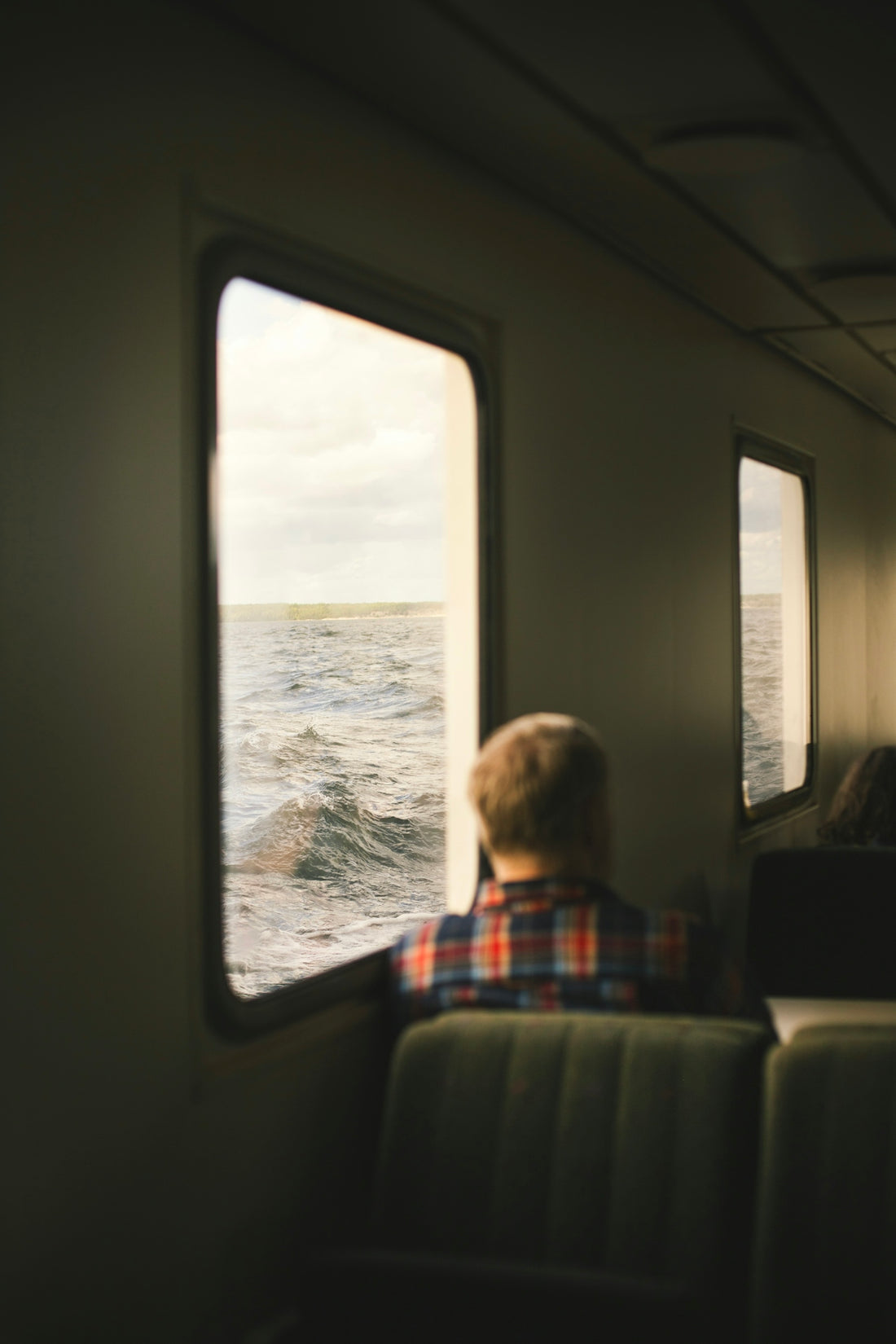 A man sitting on a train looking out the window